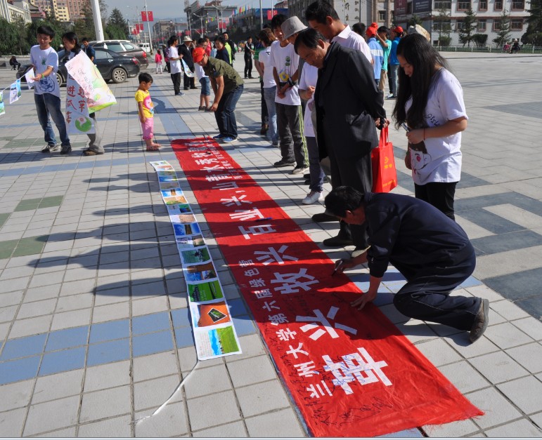 7月19日,蘭州大學(xué)第六屆綠色營(yíng)在天祝藏族自治縣政府廣場(chǎng)順利展開(kāi)了開(kāi)營(yíng)儀式。營(yíng)員們通過(guò)新穎的人體海報(bào)和圖片墻在廣場(chǎng)宣傳,吸引了許多市民的關(guān)注與駐足。圖為市民在條幅上留下了自己的簽名和感言。